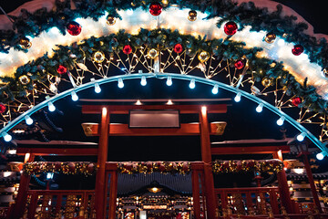 Chinese New Year outdoors winter decoration in European style arch covered with snow at the enter to temple with street lights in the night eve of Chinese New Year celebration as Chinese New Year back