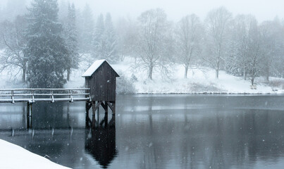 Kranicher Teich with a harrow house on a foggy winter morning with snow, Hahnenklee, Goslar, Lower...