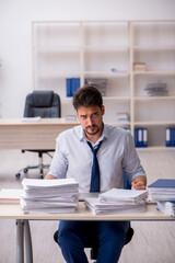 Young male employee unhappy with excessive work in the office