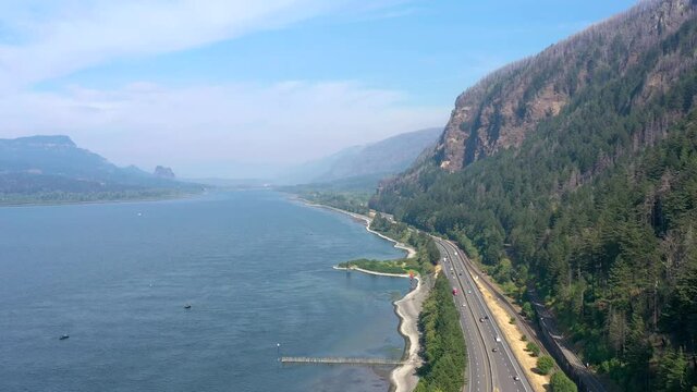 Aerial flying above Interstate 84 freeway and the Columbia River Gorge near Multnomah Falls in Oregon.