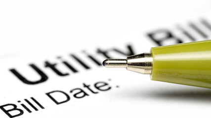 Close up shot of Green ball point pen on a utility bill.