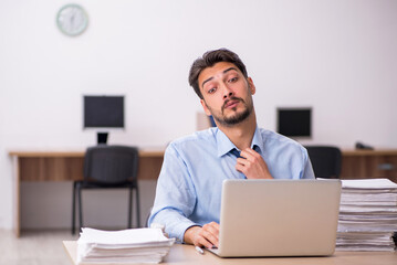 Young male employee and too much work in the office