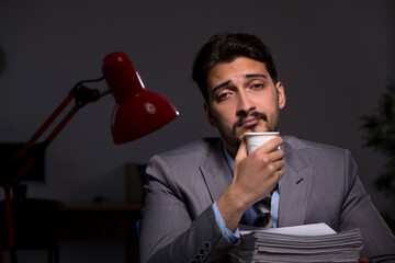 Naklejka premium Young male employee working late in the office