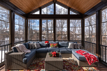 Cozy screened porch winter during Holidays season, snowy roofs and woods in the background.