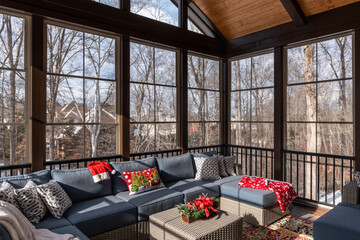 Cozy screened porch winter during Holidays season, snowy roofs and woods in the background.
