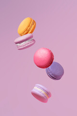 Multicolored macaron almond cakes take off on a purple background. Color of the year, pantone.