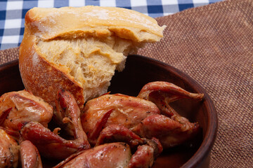 Rustic dinner. Roasted quail meat and white bread. Close-up