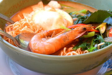 Thai Spicy creamy Tom Yum instant noodles with king prawns, egg and vegetables, seasoning with red chili, lemongrass
