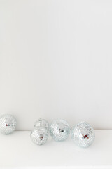 Disco mirror ball in the interior. Mirror disco ball on a white background. Minimalistic home decor. 