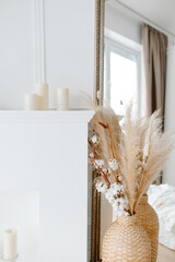 White interior in minimalism style. Dried flowers pampas grass and cotton in a vase. Beautiful and stylish interior.