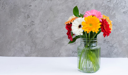 Bouquet of colorful gerberas in a glass vase on the table