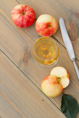 A glass of apple wine,cider, juice . Ripe summer apples are lying nearby