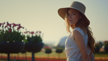 Fototapeta premium Sensual woman looking at camera outdoors. Beautiful girl turning face to sun. 