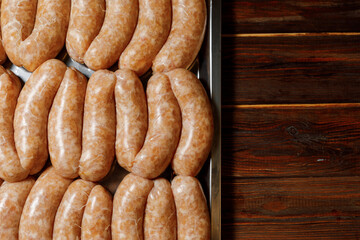 The chef is presenting a new portion of sausages to the others.