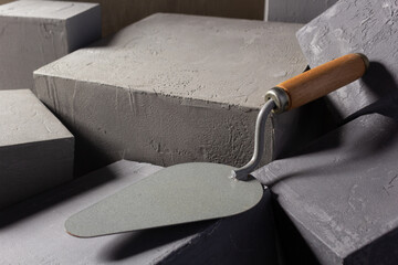 Concrete cube or construction brick and trowel. Construction concept with mason