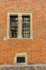 Fototapeta na wymiar Building wall with a window and wrought iron bars.