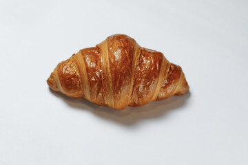 The waiter placed a delicious croissant on the table.