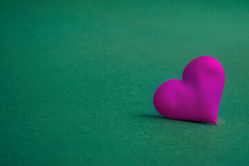Composition for Valentine's Day. On a green background, pink hearts closeup with copy space