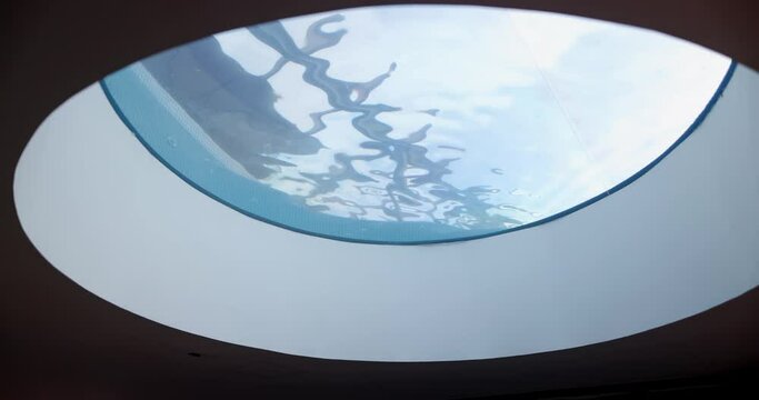 Smooth view of blue wavy water through round window