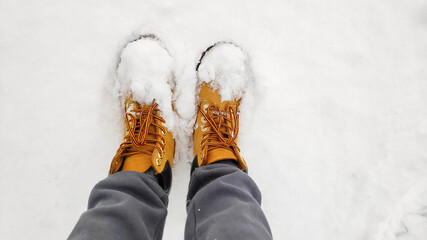 Close up top above view of female womens legs in tracking shoes, boots, sneakers on white icy snow...