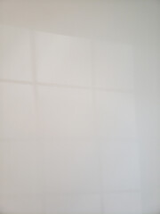 Faint Shadows of a Window on a White Wall