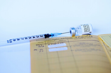 Corona Covid-19 Impfung mit Impfpass, Spritze und Impfflasche