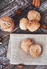 Oat cookies with ingredients on wooden background.