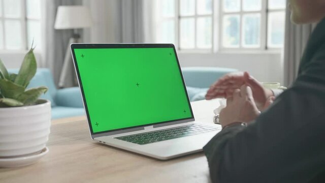 Asian Businessman Wearing Business Suit Talking On Green Screen Computer While Working At Home.
