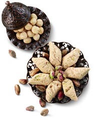 Bronze plate with date nuts and arabian sweet on the background. Ramadan kareem.