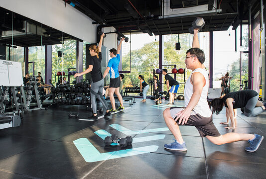 people working out during group fitness training at gym in Bangkok