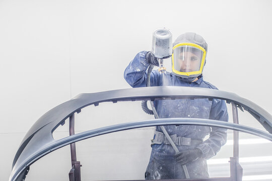 Female Auto worker painting fender