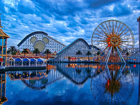 The bright colorful lights of Disney's California Adventure amusement park is reflected in the lake