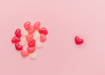 Romantic symbol. Top view photo with copy space. Many colorful candies in heart shape on pink backdrop