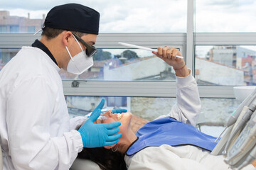 Male dentist checking a patient's teeth. Dental clinic concept