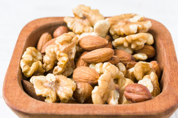 Assortment of nuts close up on wooden bowl. Healthy diet concept