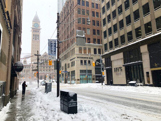 Fototapeta premium Toronto, Canada, on January 17, 2022. - Toronto snow storm paralyzed the city life. People and cars go along the streets alongside massive snowdrifts.