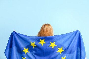 Mature woman with flag of European Union on color background, back view