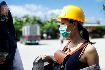 Beautiful Asian Architect Engineer women in yellow hard hat has conversation chat client manager