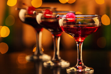 Glasses of tasty Manhattan cocktail on table in bar