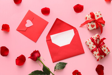 Composition with envelopes, card, gifts and rose petals on color background. Valentine's Day celebration