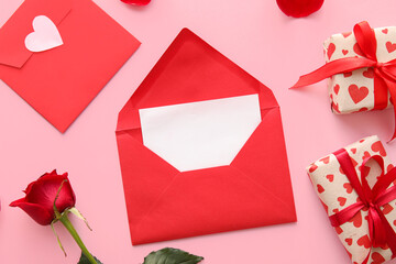 Envelope with blank card, rose flower and gifts for Valentine's Day on pink background, closeup