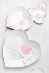 Beautiful heart shaped plates for Valentine's Day on white background