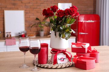 Gifts for Valentine's Day and rose flowers with glasses of wine on table in kitchen