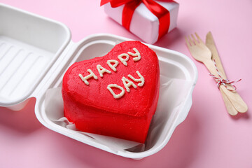 Plastic lunch box with tasty bento cake for Valentine's Day on pink background