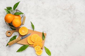 Basket with fresh juicy oranges on light background