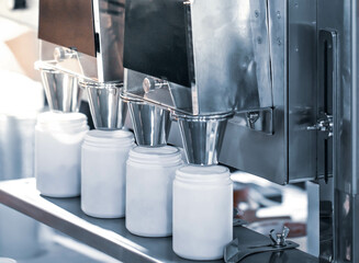 Medical pills filling in plastic bottle package on conveyor. Pharmaceutical industry.