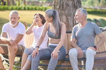 Group of people resting after the workout and feeling joyful