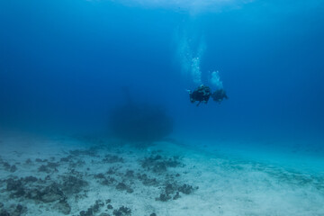 Fototapeta na wymiar divers enjoying a deep wreck ship