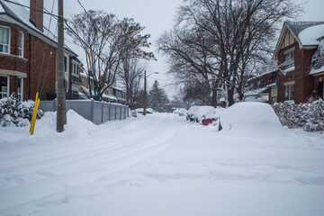 Toronto, Ontario / Canada - January 17, 2022 - Toronto St Clair West sideroad with cars covered on day of snowstorm