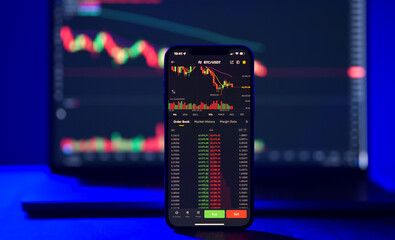 The evolution of the crypto currency coin industry. Detail view of a smartphone in front of a...
